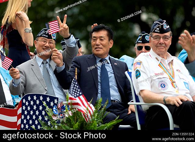 Washington, D.C., USA - May 28, 2018: The National Memorial Day Parade, Korean War Veteran going down constitution avenue waving American and South Korean Flags
