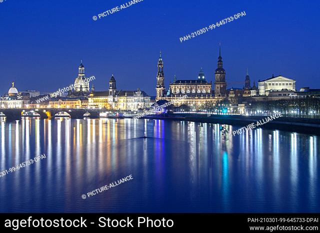 01 March 2021, Saxony, Dresden: View in the evening from the Marienbrücke to the old town scenery at the Elbe river with the dome of the academy of arts (l-r)