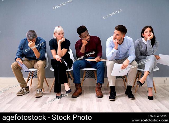Business People Are Getting Bored While Sitting On Chair Waiting For Job Interview In Office