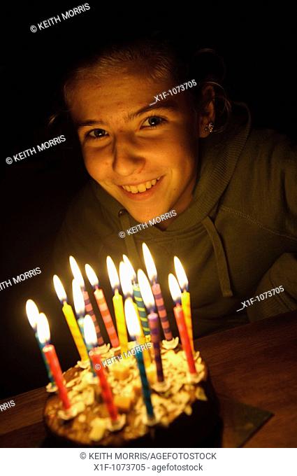 Fifteen year old Welsh teenage girl blowing out the candles on her birthday cake