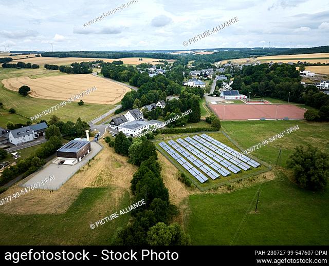26 July 2023, Rhineland-Palatinate, Neuerkirch: The combined heat and power plant (l) and a solar thermal system heat around 165 households in the Hunsrück...