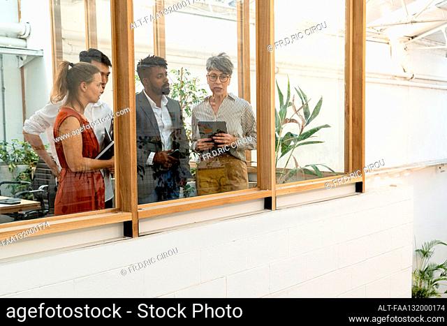 Business people discussing while looking through the window