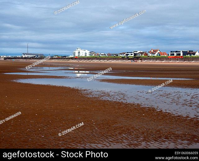 Southport, Merseyside, United Kingdom - 10 september 2020: People walking on the beach at blundell sands in crosby near southport merseyside with building and...