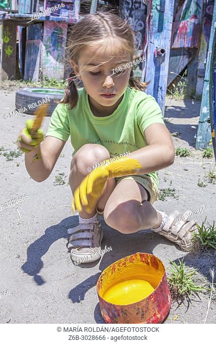 little girl playing with yellow paint