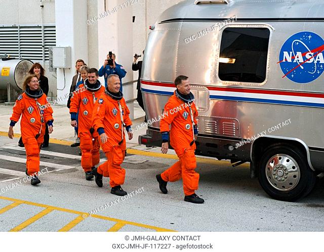 After suiting up, the STS-135 crew members exit the Operations and Checkout Building to board the Astrovan, which will take them to launch pad 39A for the...