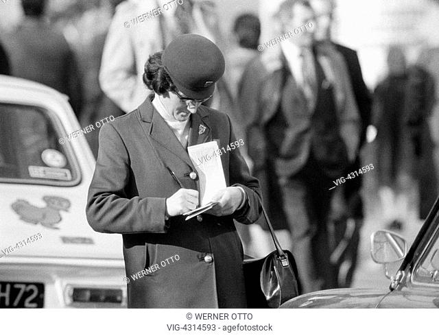FRANKREICH, PARIS, 09.02.1975, Seventies, black and white photo, road traffic, parking attendant writes a sticker though illegal parking, aged 40 to 50 years