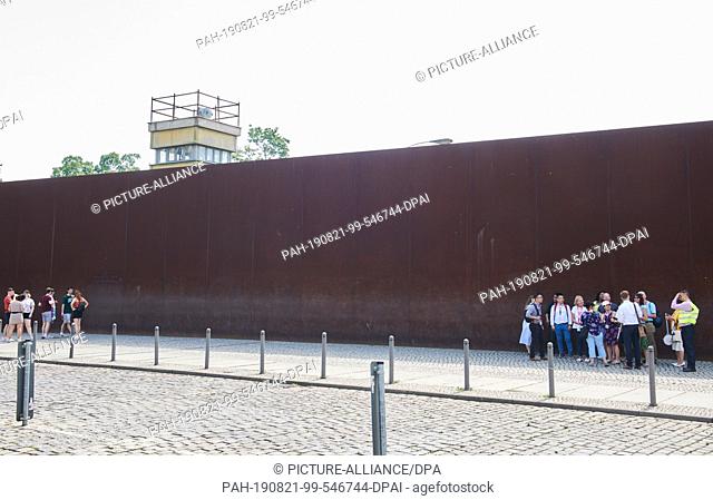 13 June 2019, Berlin: Many visitors come to the Berlin Wall Memorial on Bernauer Strasse every day. The watchtower rises above the rusty wall behind which the...