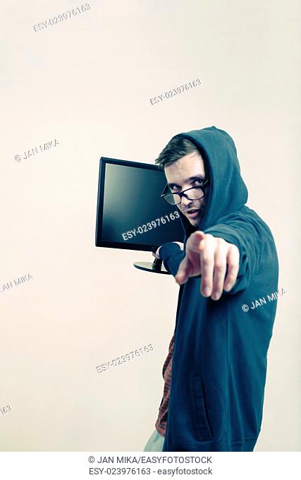 Man in hoodie holding monitor and pointing at you