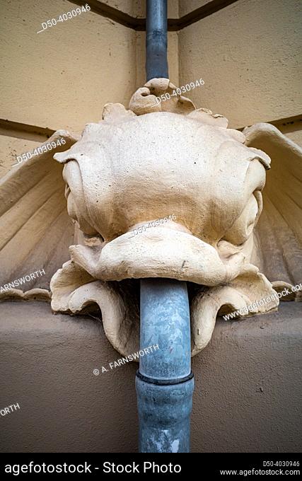 Copenhagen, Denmark, A gargoyle on the side of a house with a rain pipe coming through its mouth