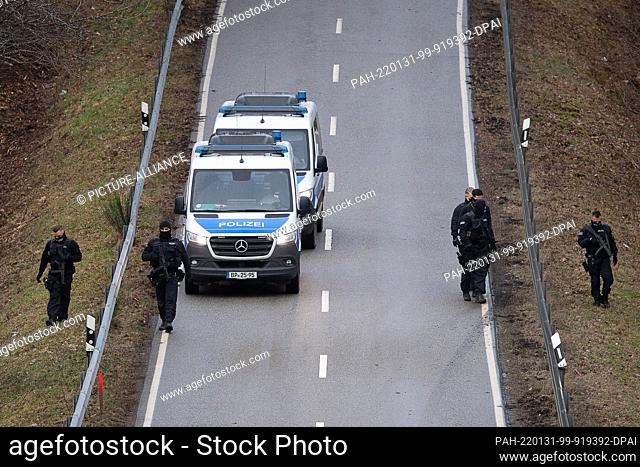 31 January 2022, Rhineland-Palatinate, Mayweilerhof: Police officers search the road on County Road 22 about a kilometer near the scene where two police...