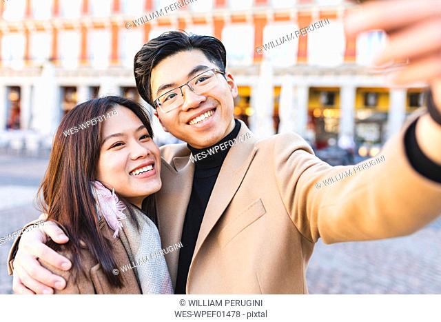 Spain, Madrid, happy young couple taking a selfie in the city