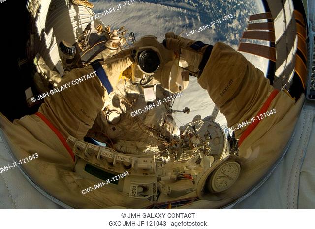 Russian cosmonaut Oleg Kotov, Expedition 22 flight engineer, uses a digital still camera to expose a photo of his helmet visor during a session of...