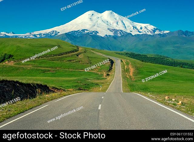 Road leading to mount Elbrus with green meadows at summer. North Caucasus, Russia