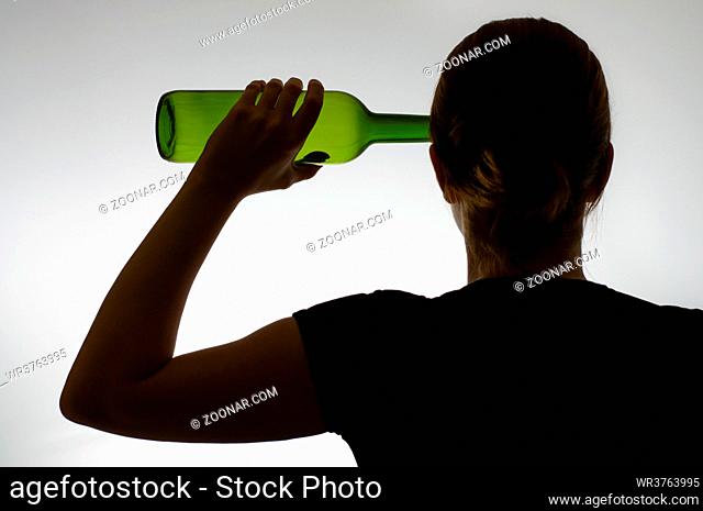 Backside view of a woman's silhouette with a wine bottle