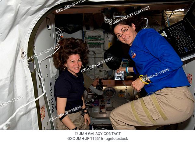 It's another moving day onboard the International Space Station, as NASA astronauts Cady Coleman (left), Expedition 26 flight engineer, Nicole Stott