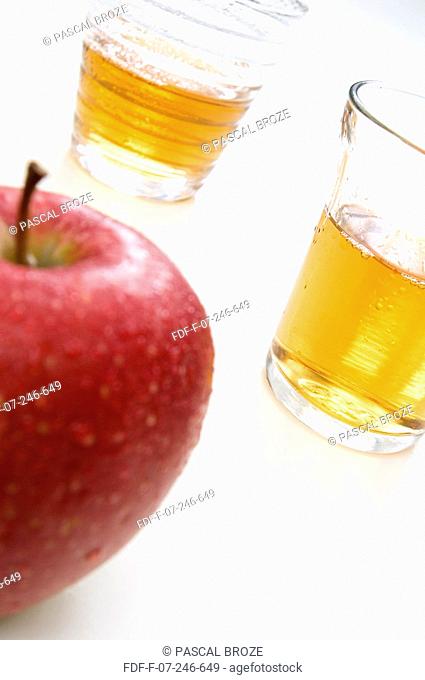 Close-up of an apple with two glasses of apple juice