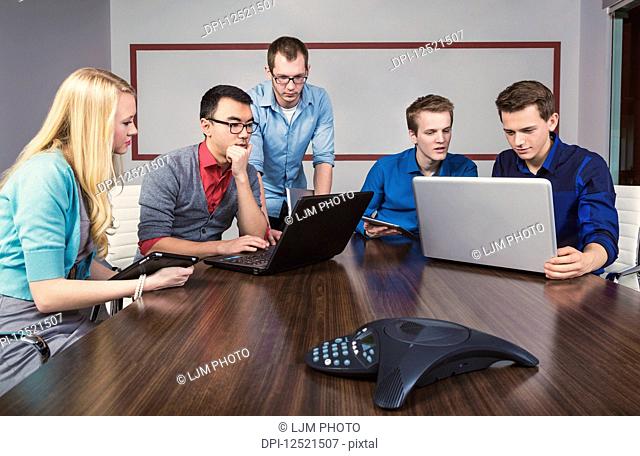 Young millennial business professionals working together in a conference room in a high tech modern business; Sherwood Park, Alberta, Canada