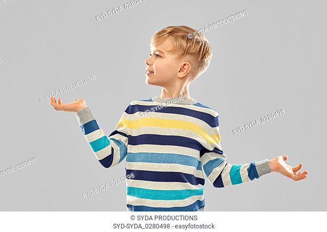 smiling boy holding something on empty hands