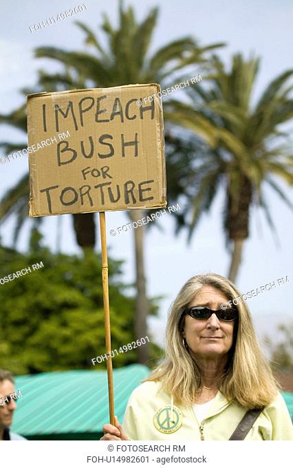 A woman holds a sign saying Impeach Bush for torture at an anti-Iraq War protest march in Santa Barbara, California on March 17, 2007