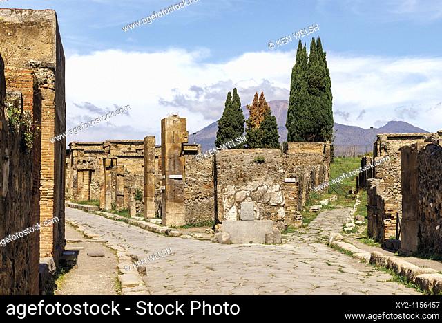 Pompeii Archaeological Site, Campania, Italy. Excavated streets. Mount Vesuvius in background. Pompeii, Herculaneum, and Torre Annunziata are collectively...