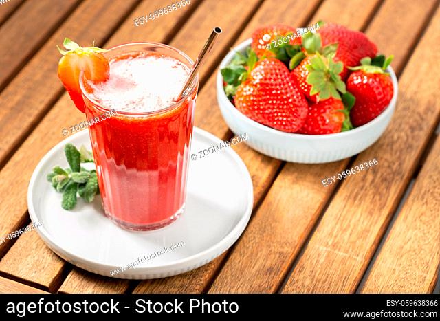 Sweet fresh strawberry juice on wooden table. Healthy food