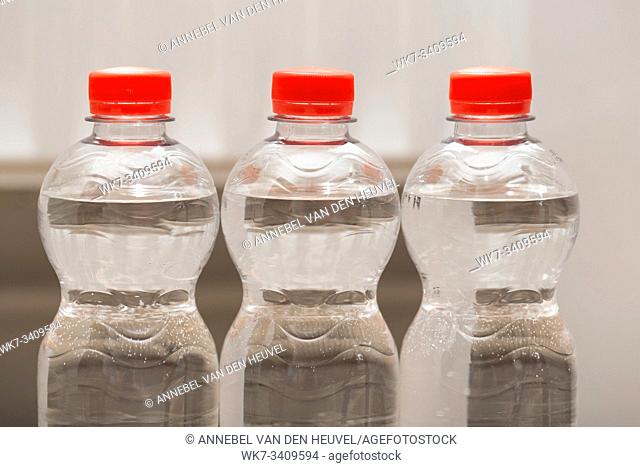 Row of water bottles, bubbling spa red, recycling environment concept close-up