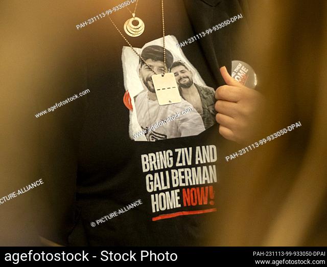 13 November 2023, Bavaria, Munich: Relatives of Israeli hostages held hostage by Hamas, who have printed pictures and names of their missing loved ones on...