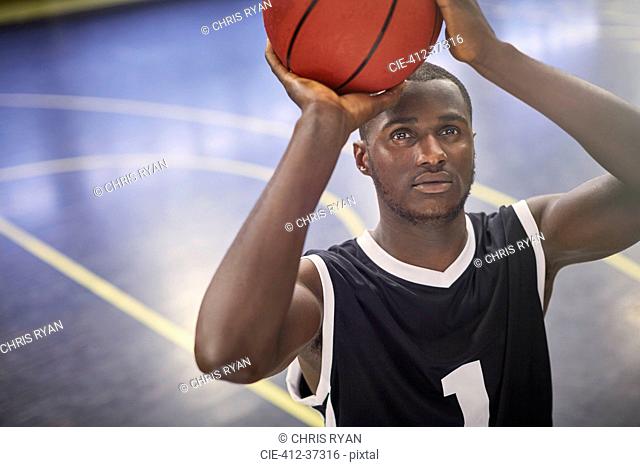 Focused young male basketball player shooting the ball on court