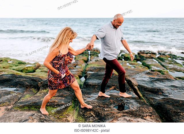 Couple walking on rocks, Estoril, Lisboa, Portugal