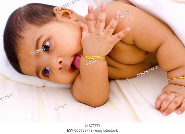 Indian baby girl licking her hand