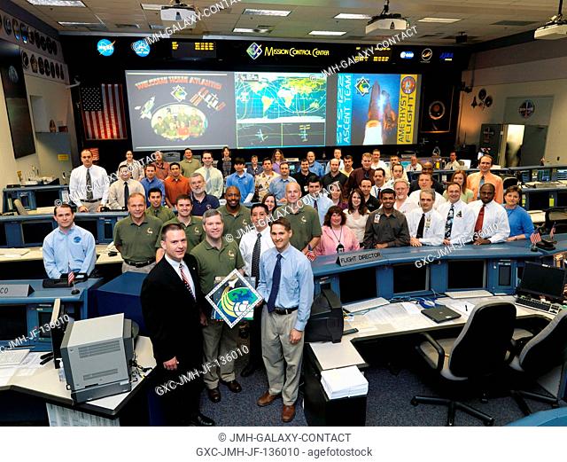 The members of the STS-122 ascent flight control team and the flight's crewmembers pose for a group portrait in the space shuttle flight control room of Johnson...