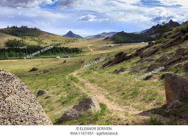 Path winds past hills and tourist ger camp towards distant mountains in summer, Terelj National Park, Central Mongolia, Mongolia, Central Asia, Asia