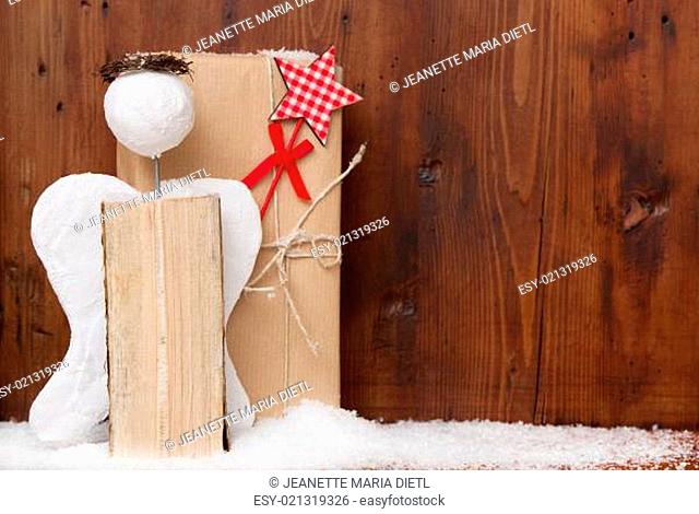 Angel with glory and magic wands for a wooden christmas background with a present
