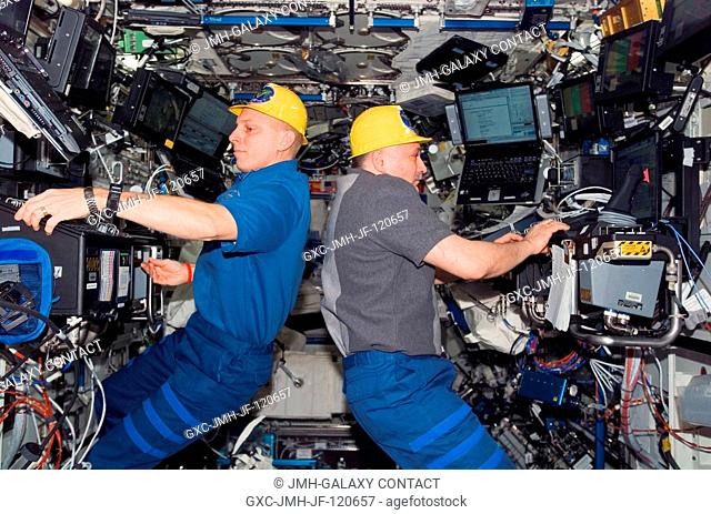Astronaut Clay Anderson (left), Expedition 15 flight engineer, works the controls of the station's robotic arm, Canadarm2; while cosmonaut Fyodor N