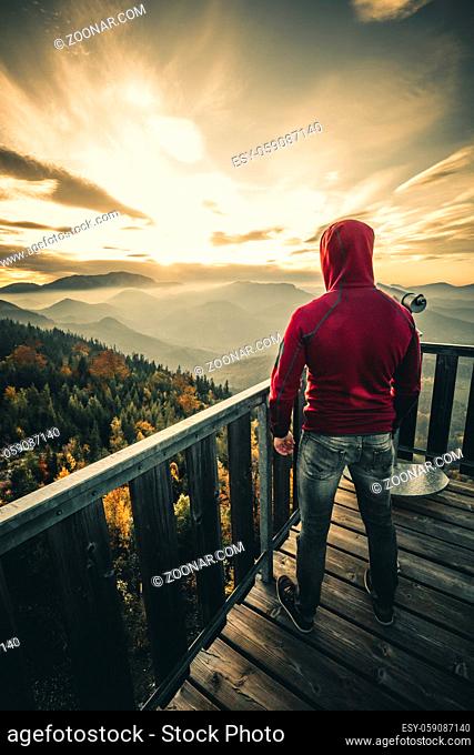 Man on top of mountain during sunset. Conceptual scene in the austrian alps