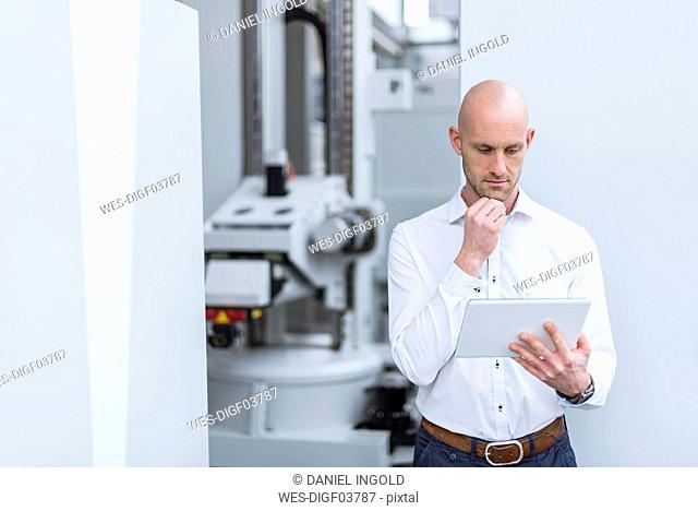 Businessman using tablet in modern factory