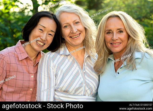 Three senior women posing together for group photo outdoors
