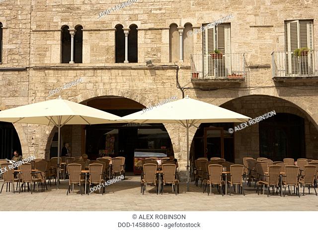 Spain, Catalonia, Banyoles, Town old quarter with sunshades and chairs