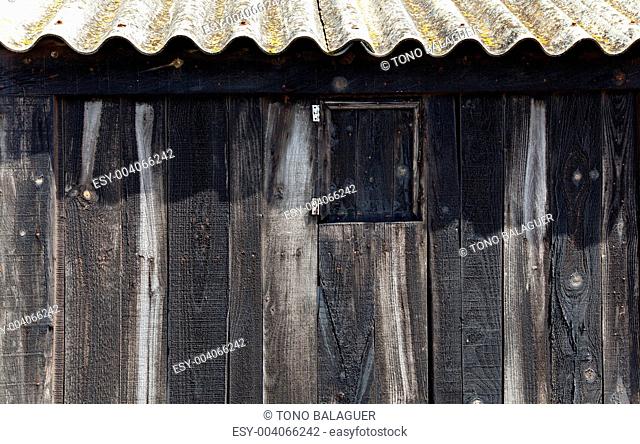 Aged black wood with wavy roof in balearic beach