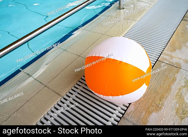 PRODUCTION - 13 April 2022, Mecklenburg-Western Pomerania, Greifswald: An inflatable beach ball lies on the edge of the pool at the Greifswald leisure pool