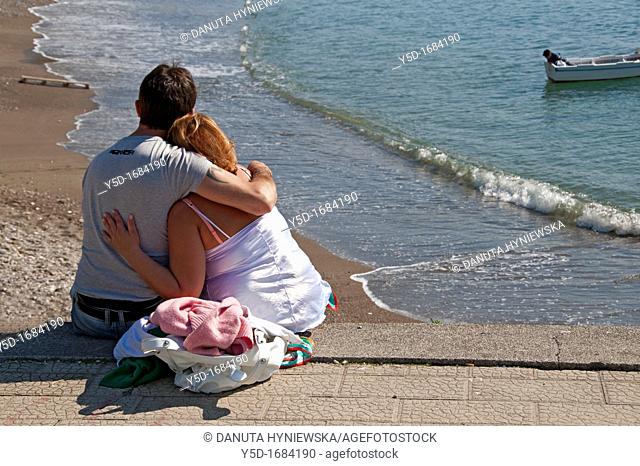Couple in love, together, sitting at the beach, Amalfi Coast, Italy, March
