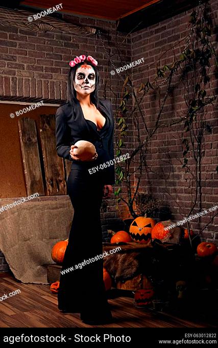 Young woman in black pantsuit and sugar skull makeup. Face painting art