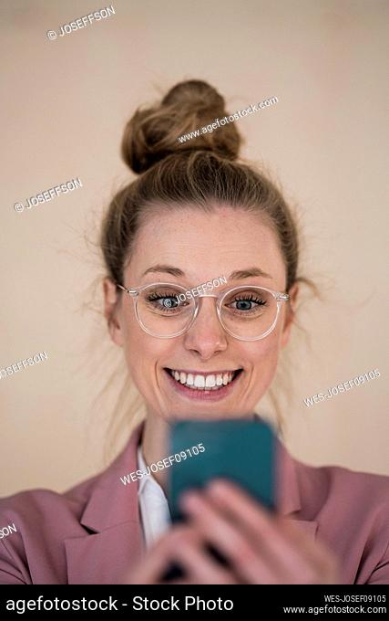 Excited businesswoman looking at smart phone