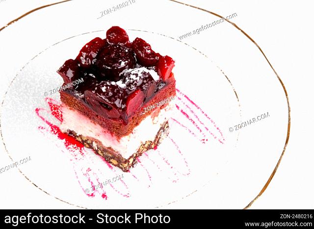 Slice of a biscuit pie with a cherry on a white plate