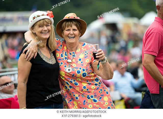 Two happy smiling laughing adult women enjoying the The Big Tribute Music festival, Aberystwyth, August Bank Holiday weekend, Summer 2015