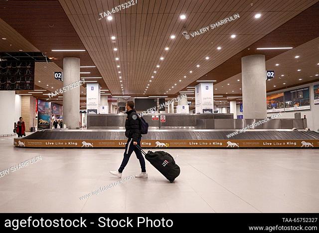 CYPRUS, NICOSIA - 14 de diciembre de 2023: Un hombre rueda a lo largo de su maleta en el aeropuerto internacional de Ercan cerca del pueblo de Tymbou