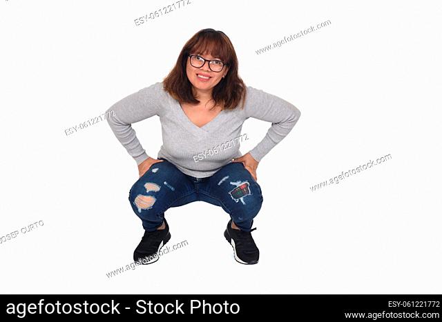 front view o f a woman squatting looking at camera white background
