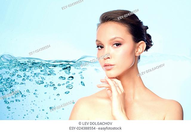 beauty, jewelry, accessories, people and luxury concept - face of beautiful young asian woman with golden ring over blue background and air bubbles in water
