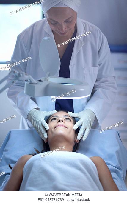 Female surgeon examining patient during plastic surgery