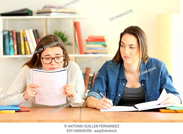 Student having eyesight problems and another one despising her while they are studying at home